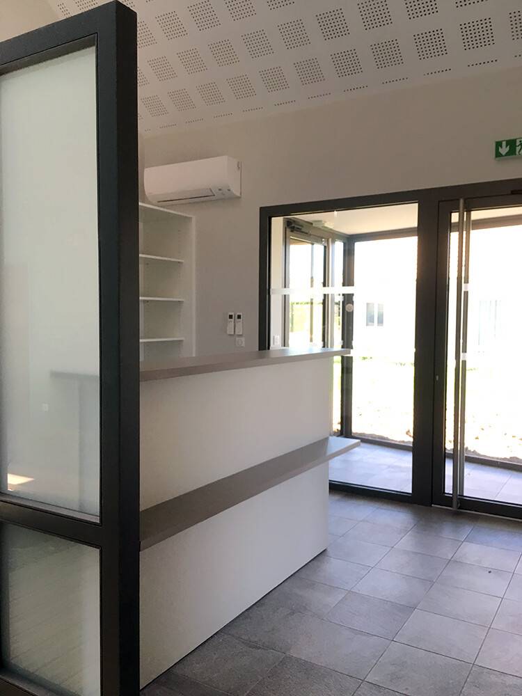 Banque d'accueil moderne avec verrière noire et baies vitrées