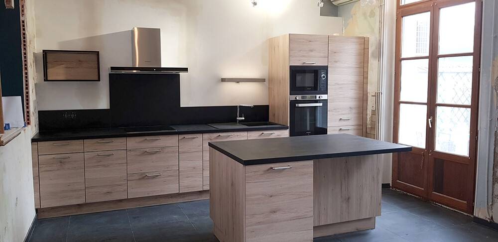 Cuisine bois clair avec îlot central dans une pièce ancienne