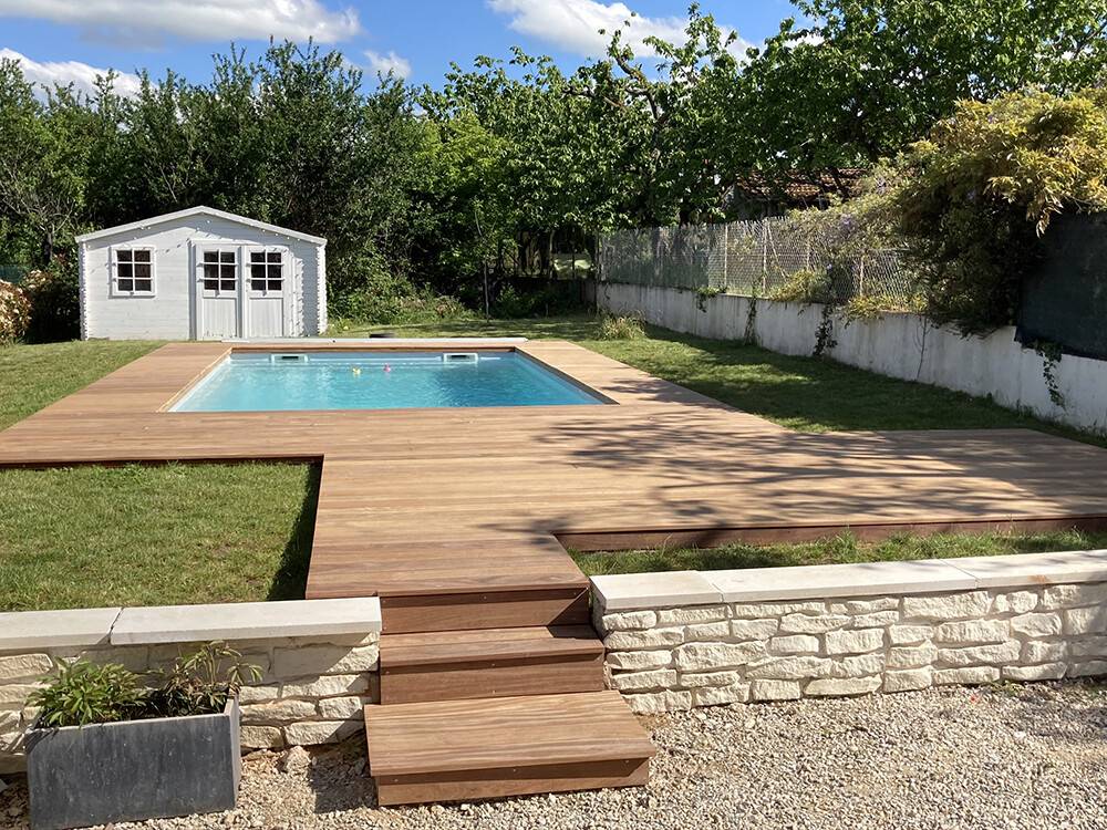 Terrasse de piscine en bois avec marches d'accès au jardin