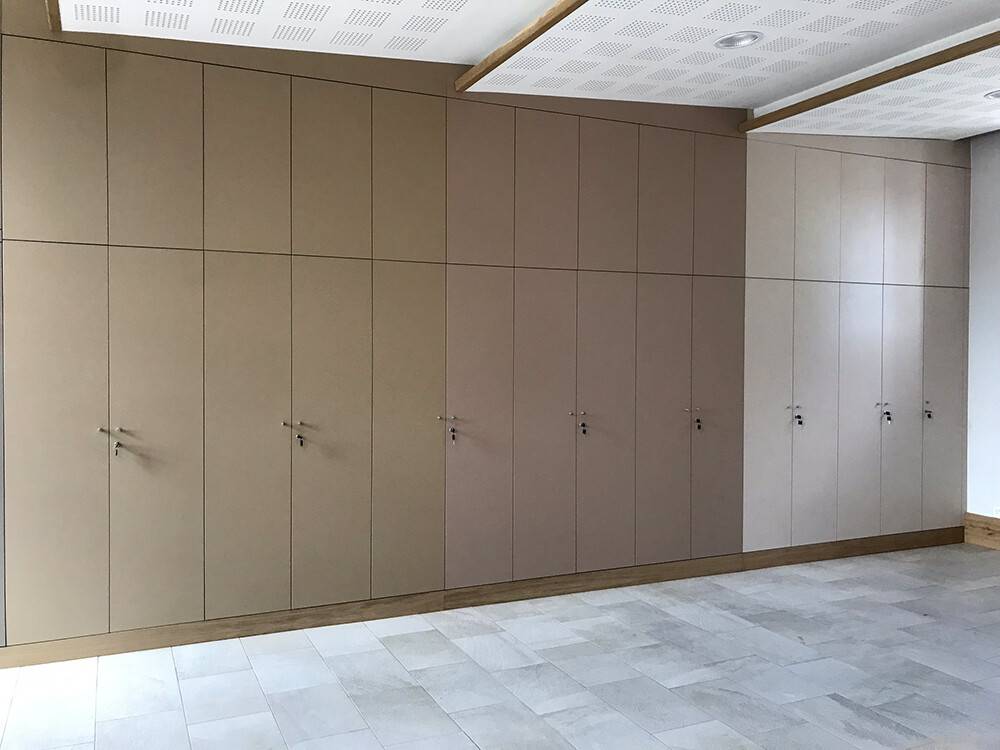 Mur de placards sur-mesure beige avec serrures pour collectivité
